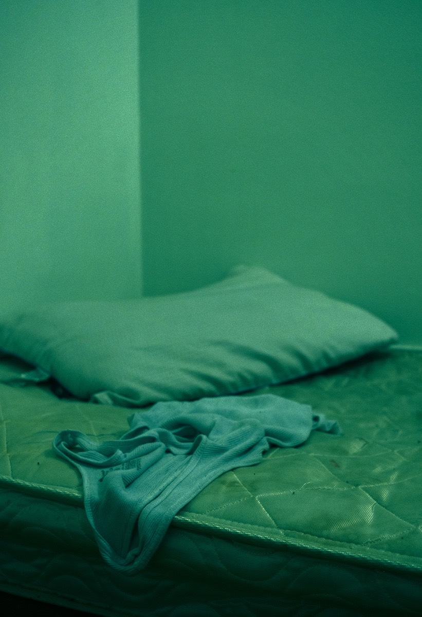 Green tinted image of unmade bed